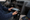 Person removes a car stereo from the dashboard, with exposed wiring and tools visible inside the vehicle.