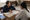 Two women sit at a table reviewing documents together in a warmly lit room.