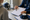 A healthcare professional reviews a clipboard with a seated person beside a football helmet and ice pack.