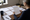 Woman reviews highlighted documents at a desk surrounded by paperwork, a notebook, coffee, and office supplies.