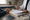 Healthcare professional reviews paperwork with a seated patient at a desk, with a stethoscope nearby.
