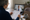 Person reviews a printed document while watching a clinician on a laptop during a video visit.