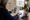 Woman reviews property listings at a dining table beside a coffee mug and smartphone.
