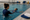 An instructor supports a child floating on their back during a one-on-one pool lesson.