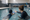 Adult instructor guides a child through the water during a one-on-one swimming lesson in an indoor pool.