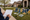 Person writes on a clipboard while graduation decorations and number 2024 lie on a suburban lawn.