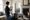 Woman holds a clipboard beside cleaning supplies and material samples on a living room table.