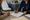 A healthcare professional reviews paperwork with a seated patient in an examination room.