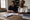 Two adults review documents together at a wooden table inside a modest office.