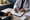 Healthcare professional fills out a form while a patient sits across the desk in a clinic.