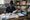 Healthcare worker reviews paperwork while organizing medical supplies on a table in a storeroom.