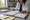 A healthcare professional in a white coat reviews paperwork at a desk with folders and a stethoscope.