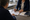 A healthcare professional and another person review paperwork together at a desk in a medical office.