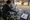 Person arranges assorted star, sports, and graphic cutouts on a worktable beside a window.