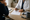 Clinician reviews a printed chart with a seated person at a desk, with a stethoscope and coffee mug nearby.