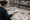 A woman sketches a decorative sign at a worktable surrounded by star and sports-themed cutouts.