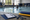 Swim instructor works with a swimmer in an indoor pool beside a clipboard, whistle, and flotation boards.