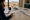 Person studies a map at a kitchen counter overlooking a desert neighborhood and mountains.