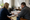 Two people review documents together at a desk in a sunlit office.