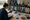 Person writes on a clipboard at a table surrounded by assorted star, sports, number, and speech-bubble signs.