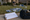 Worker arranges star and balloon yard sign pieces on a lawn beside a layout plan and tool bag.